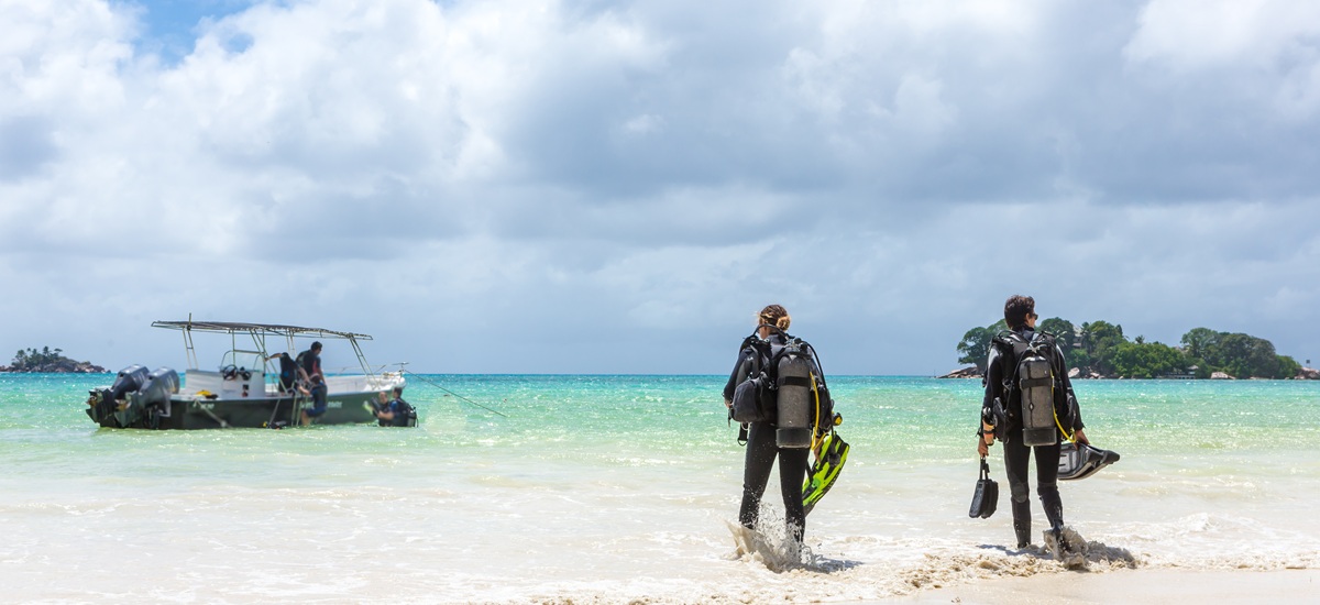 Divers Walking on Beach in Seychelles.